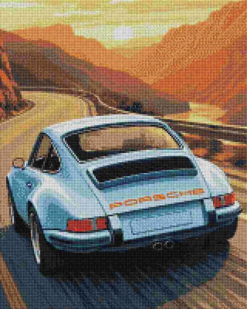 A stylized artwork of a light blue Porsche rear view driving on a winding mountain road at sunset, with orange-brown hills and a glowing sky. Porsche Sunset Drive - Diamond Art